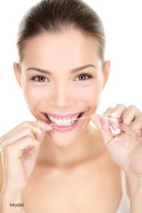 Young Woman Happily Flossing Teeth