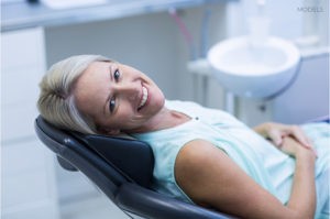 Older Woman Smiling and Laying on Examination Chair