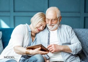 Old Man and Woman Researching Dental Implant Failure on Tablet